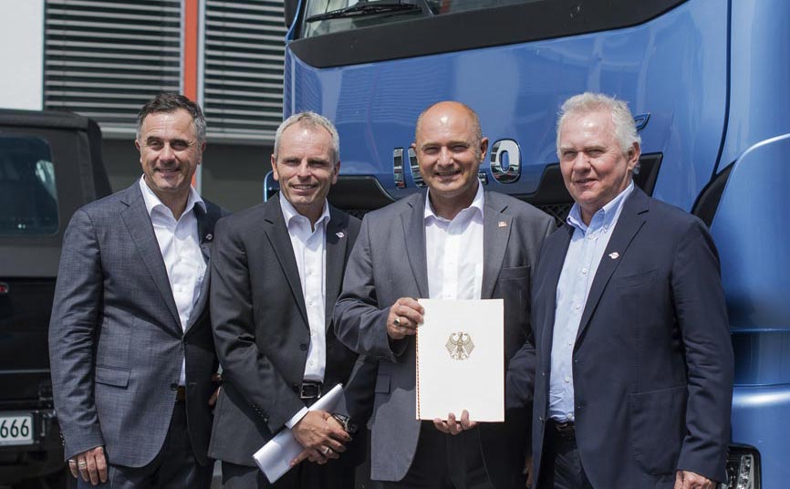 Staatssekretär im Bundesministerium für Verkehr und digitale Infrastruktur Rainer Bomba (2. von rechts) übergibt den Zuwendungsbescheid für die Anschaffung von 20 neuen IVECO Stralis NP LNG-Lkw an die Geschäftsführer von Meyer Logistik Heinz Meyer (rechts), Markus Bappert (links) und Matthias Strehl (2. von links).