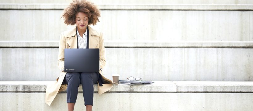 Junge Geschäftsfrau mit Laptop auf einer Treppe