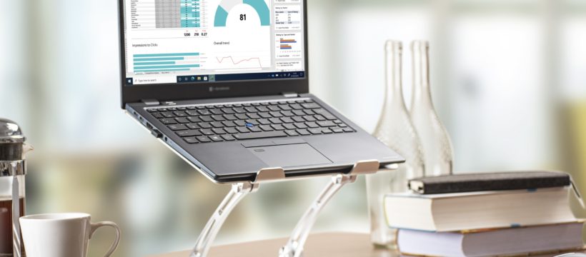 Zu sehen ist ein Notebook, dass auf einem erhöhten Standfuß auf einem Schreibtisch steht. Der Standfuß ermöglicht einen komfortablen Blick auf das Notebook für den Nutzer.